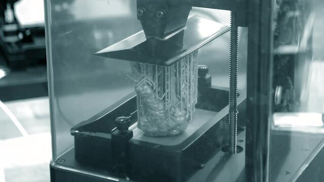 Working of photopolymer sla 3D printer. Platform with building object lowered into liquid photopolymer resins and hardened under ultraviolet laser. Progressive additive technology. 3D printer printing