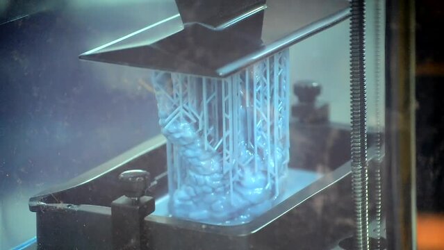 Working of photopolymer sla 3D printer. Platform with building object lowered into liquid photopolymer resins and hardened under ultraviolet laser. Progressive additive technology. 3D printer printing