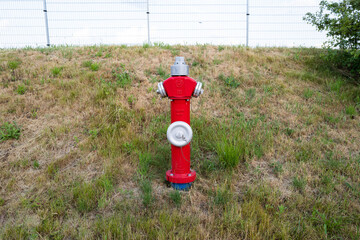 roter Wasser-Hydrant auf trockener Wiese für Feuerwehr und Löschwasser