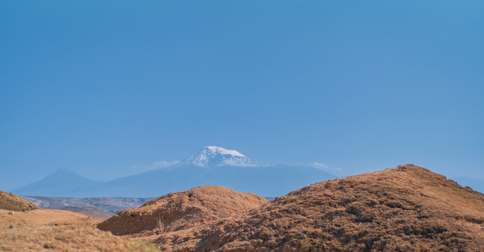 View from Arin Berd hill and Erebuni fortress to the majestic peak of snowy Ararat. Traveling to popular places, heritage of human history, idea for banner or postcard