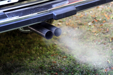 Double car exhaust smoking. Auto ignition warming up engines. Environmental pollution by car smoke. Vehicle pollution. Air pollution by carbon monoxide. smog.
