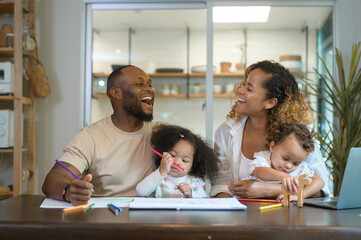 Fototapeta premium Happy African American parent playing and drawing with daughters in home