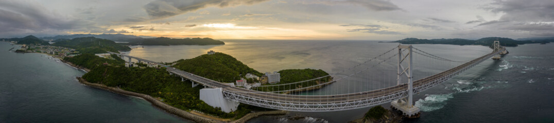 Panoramic aerial view of suspension bridge on coast at sunset