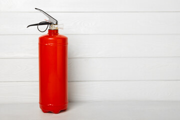 Fire extinguisher on a light texture background. Fire protection, home fire extinguisher. home...