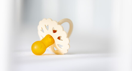 Baby's pacifier on a blurred white background.