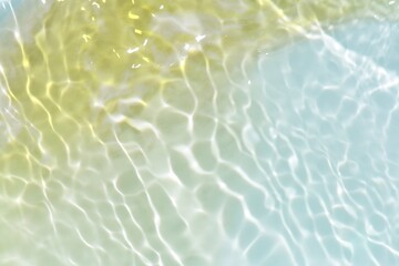 Blue water with ripples on the surface. Defocus blurred transparent blue colored clear calm water surface texture with splashes and bubbles. Water waves with shining pattern texture background.
