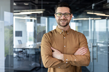 Portrait of a young male programmer, creative designer, developer engineer. He stands in the office...