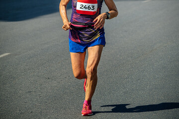 elderly female runner athlete running marathon race, world masters athletics