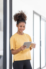 Young pretty employee business african american woman work in office with tablet pc computer. Concept of surfing web with browse use pad gadget