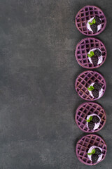 Obraz na płótnie Canvas Blackberry round waffles with cream cheese and fresh blackberries. Dark gray background. Top view