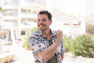 Fototapeta premium handsome man feeling happy, positive and successful, motivated when facing a challenge or celebrating good results