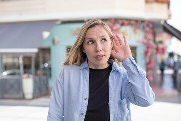pretty woman looking serious and curious, listening, trying to hear a secret conversation or...