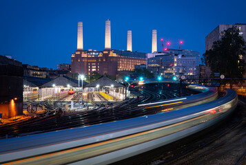 Battersea Power Station at night. Train with light trails