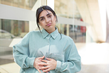 pretty woman with a goofy, crazy, surprised expression, puffing cheeks, feeling stuffed, fat and...