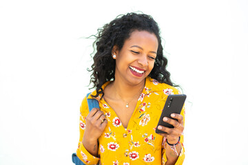 Cheerful young african woman looking at cellphone against white background