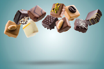 Assorted chocolate pralines floating on blue background - 617099408
