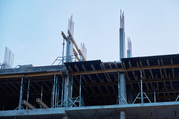 Demonstration of cast-in-place reinforced concrete structures from which reinforcement sticks out. The construction site is at an initial stage. Construction of a new building.