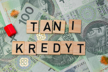 The inscription Tani Kredyt next to Polish zlotys. Credit for an apartment in Poland. Election promises