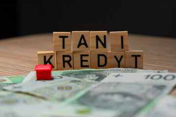 The inscription Tani Kredyt next to Polish zlotys. Credit for an apartment in Poland. Election...