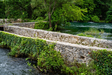 Old cobblestone bridge over water in Croatia  