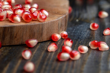 Red pomegranate seeds on the table and the board