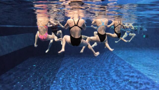 Synchronized swimming junior team underwater training in the swimming pool