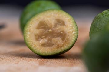 Green ripe feijoa cut in half on a board