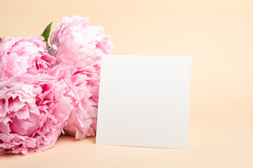 Blank square card mockup with fresh peony flowers, card with copy space
