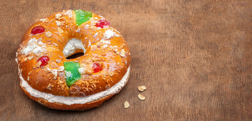 Epiphany cake Roscon de Reyes on a wooden  background. Spanish dessert of three kings cake eaten on epiphany day.