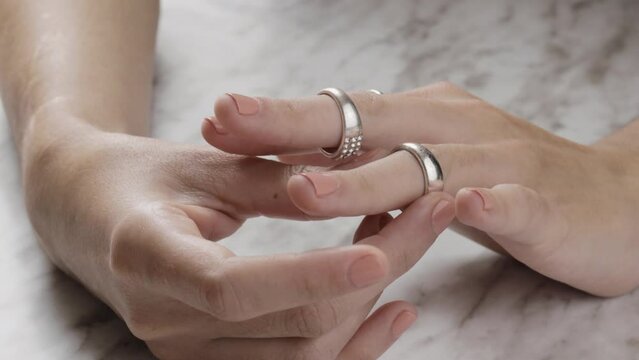 putting a ring on the ring finger, lifestyle and silver jewelry, background and objects in studio
