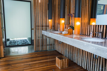Fototapeta premium Luxury modern hotel bathroom interior detail. Hand towel, soap dispenser and sink basin on a marble top at Costa Rica. Luxury travel vacation concept