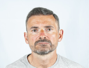 Portrait of sad aged  beard man  close up on a gray background