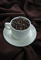 Coffee beans in a coffee mug isolated on brown colour background