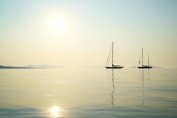 Sailing boats at anchor on the Aegean Sea in early morning light