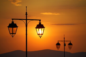 Streetlights against the Rising Sun