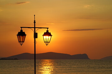 Street Lights at Sunrise against islands of the Aegean Sea - 617119019