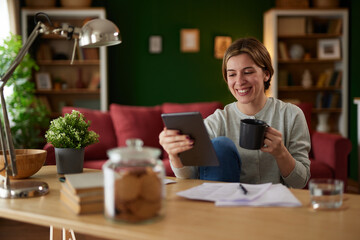 Women using digital tablet to check her finances at home office