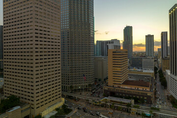 Obraz premium Aerial view of downtown district of of Miami Brickell in Florida, USA at sunset. High skyscraper buildings and street with cars and Metrorail traffic in modern american midtown