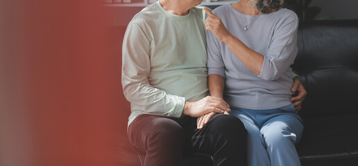 Embraced mature couple surfing the Internet on laptop at home