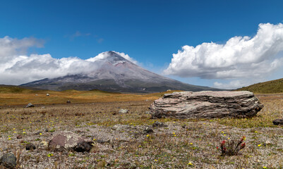 Old and big volcanic rocks thrown out by the Cotopaxi volcano millions of years ago, lie in plain sight and undisturbed, with the majestic volcano in back. ND filters used to capture cloud movement.