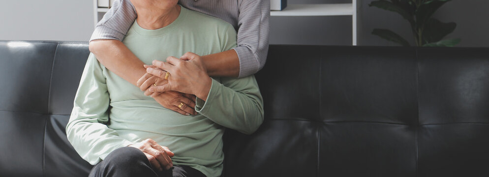 Embraced mature couple surfing the Internet on laptop at home