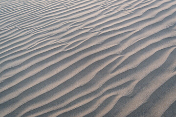 Waves in the sand of the dunes at sunset