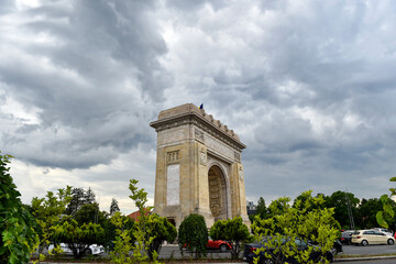 The Triumph Arch in Bucharest with storm clouds above.