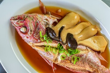 Flavors of the Sea: Top Close-Up of Whole Red Snapper Fish Cooked in Ginger Soy Sauce on Plate in 4K