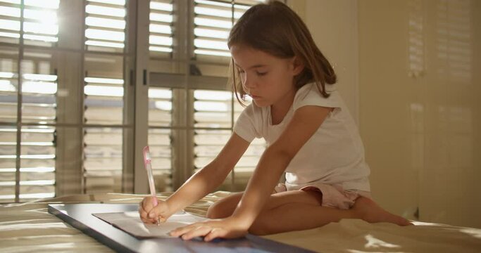 Empowering Minds: Unleashing Creativity as a Young Girl Writes and Explores on the Comfortable Couch. High quality 4k footage