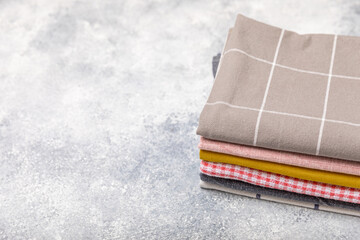 A stack of kitchen towels on a marble background. New kitchen cotton towels on the kitchen table. A set of towels. Home textiles. Place for text. copy space.