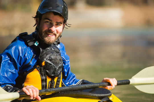 A man smiles while paddling whitewater in a yellow kayak on the Chattahoochee River in Atlanta, Georgia, close up