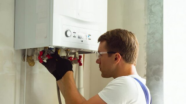 Serious technician setting the new gas boiler for hot water and heating