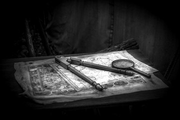 The old map on the table and the compass and the magnifying glass on it