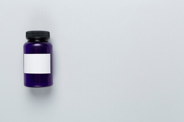 Plastic bottle with vitamins on color background, top view